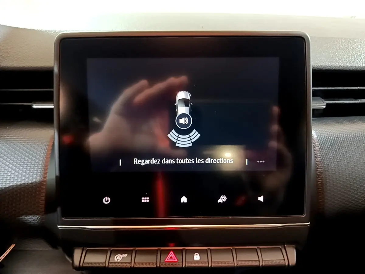 Écran tactile central de la Renault Clio Business blanc 2021 affichant l'alerte de surveillance des angles morts.