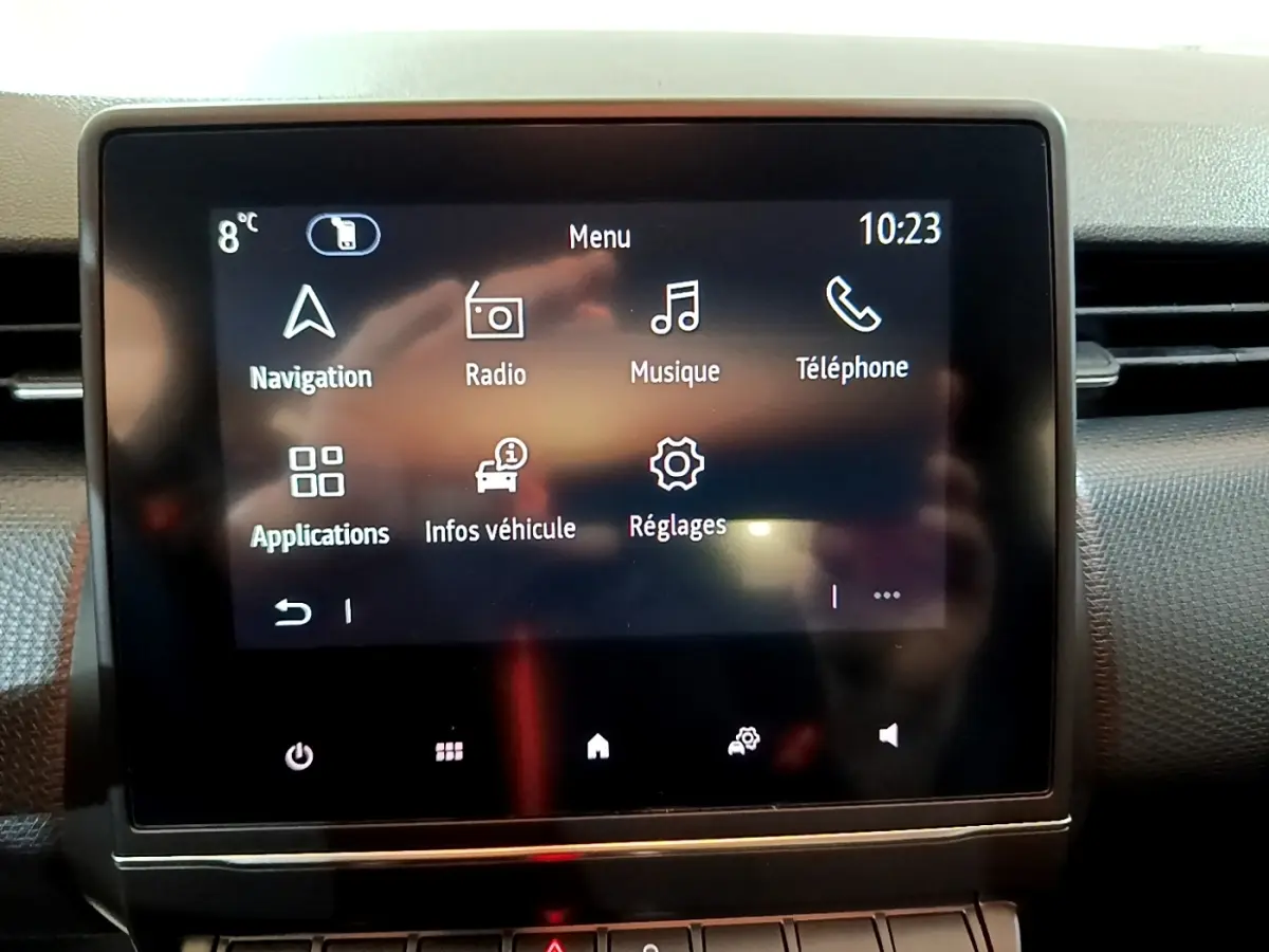 Écran tactile central affichant le menu multimédia de la Renault Clio Business blanche, vue intérieure frontale.