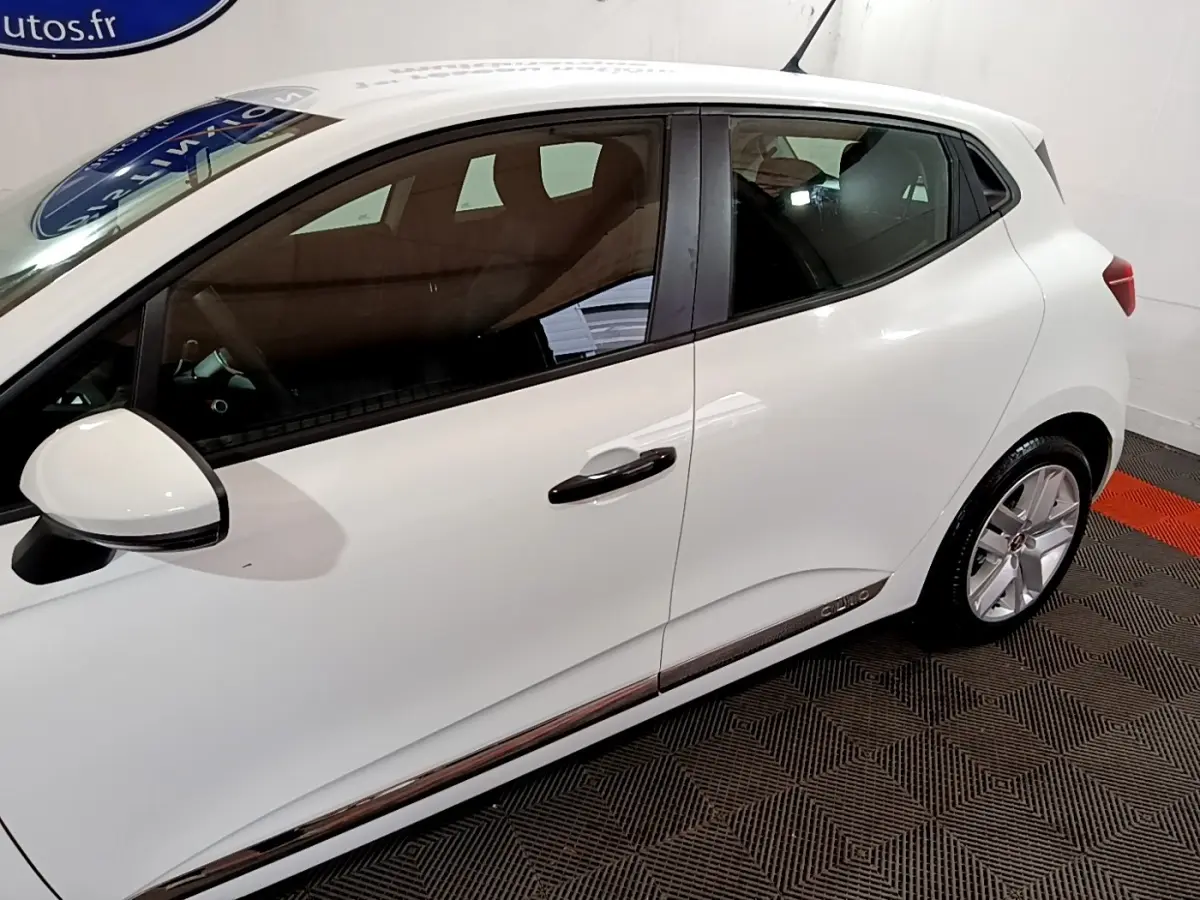 Profil droit d'une Renault Clio Business blanche 2021 avec poignées noires et jantes alliage visibles.