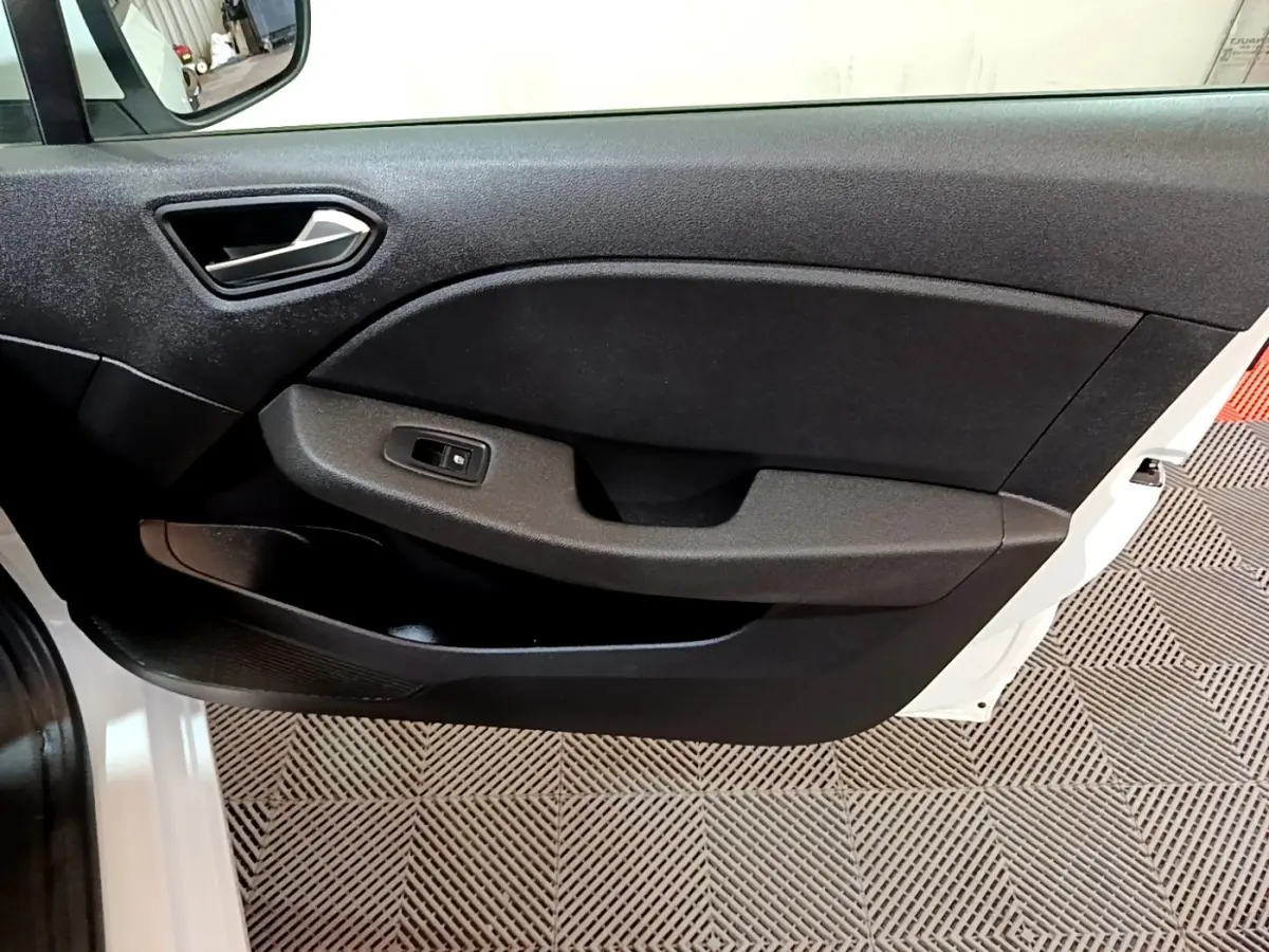 Intérieur de la porte avant gauche d'une Renault Clio Business blanche, avec poignée et commande de vitre noire.