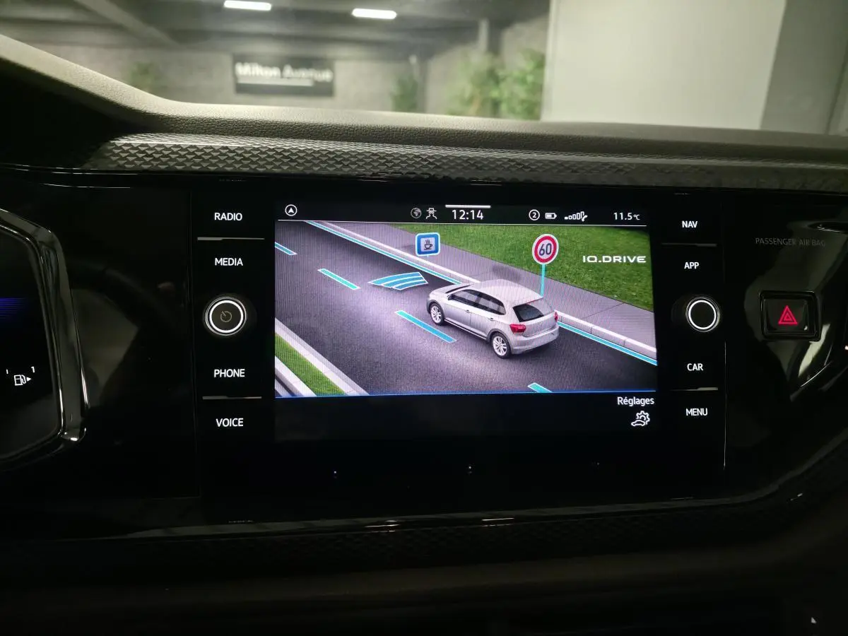 Écran tactile du tableau de bord affichant la fonction IQ.DRIVE avec une Polo grise vue de dessus en simulation.