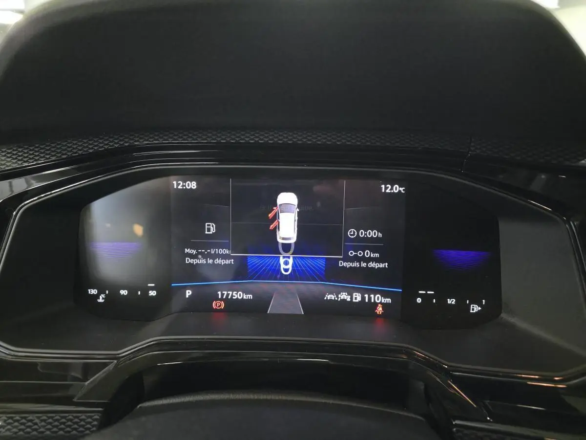 Vue rapprochée du tableau de bord numérique de la Volkswagen Polo gris 2025 avec affichage des alertes et kilométrage.