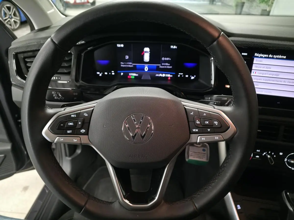 Vue rapprochée du volant cuir multifonction noir de la Volkswagen Polo 2025 avec tableau de bord digital et écran tactile.