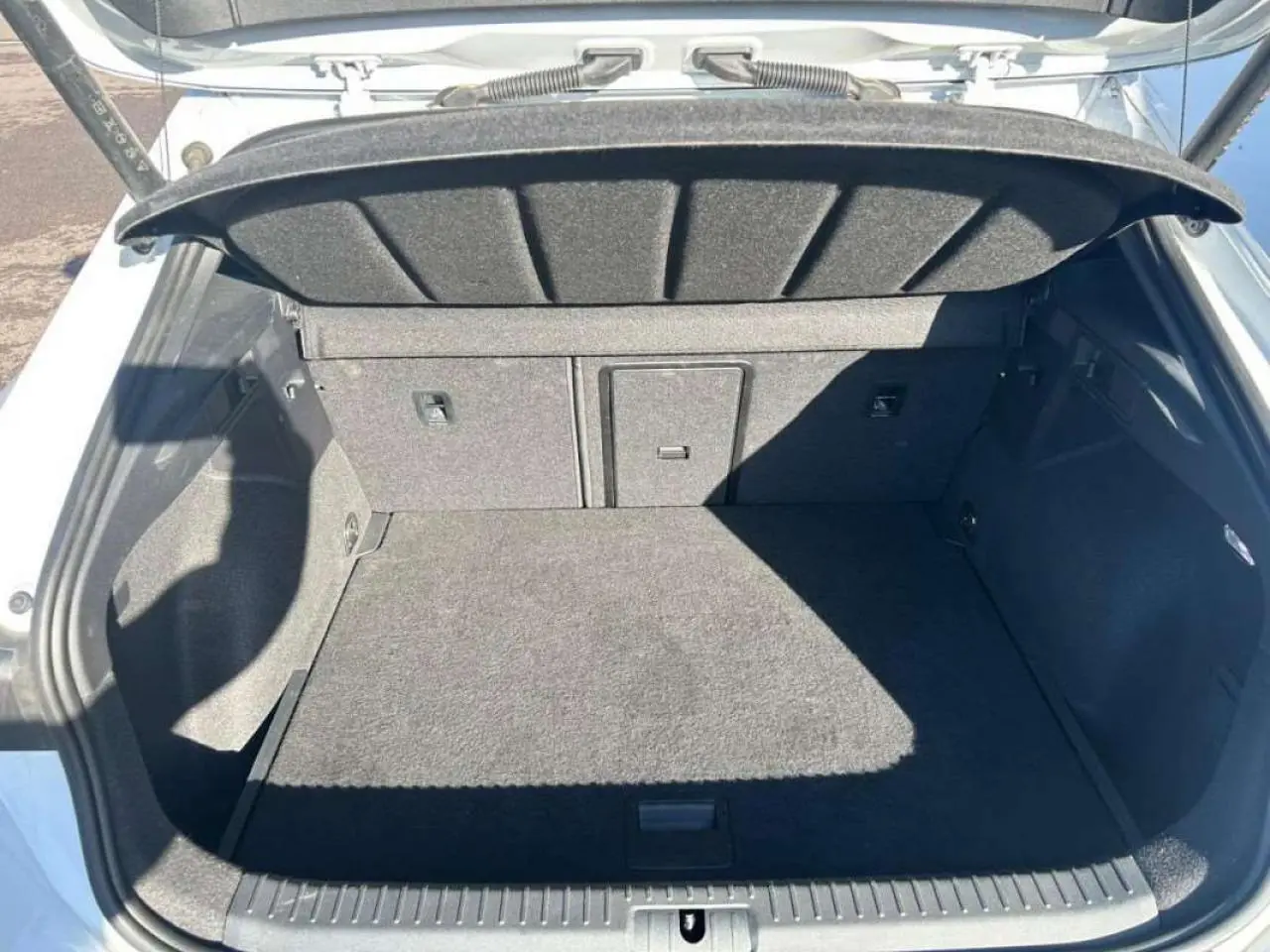 Coffre ouvert vu de l'arrière d'une CUPRA Formentor blanc 2025, montrant un espace de chargement vide et doublure grise.