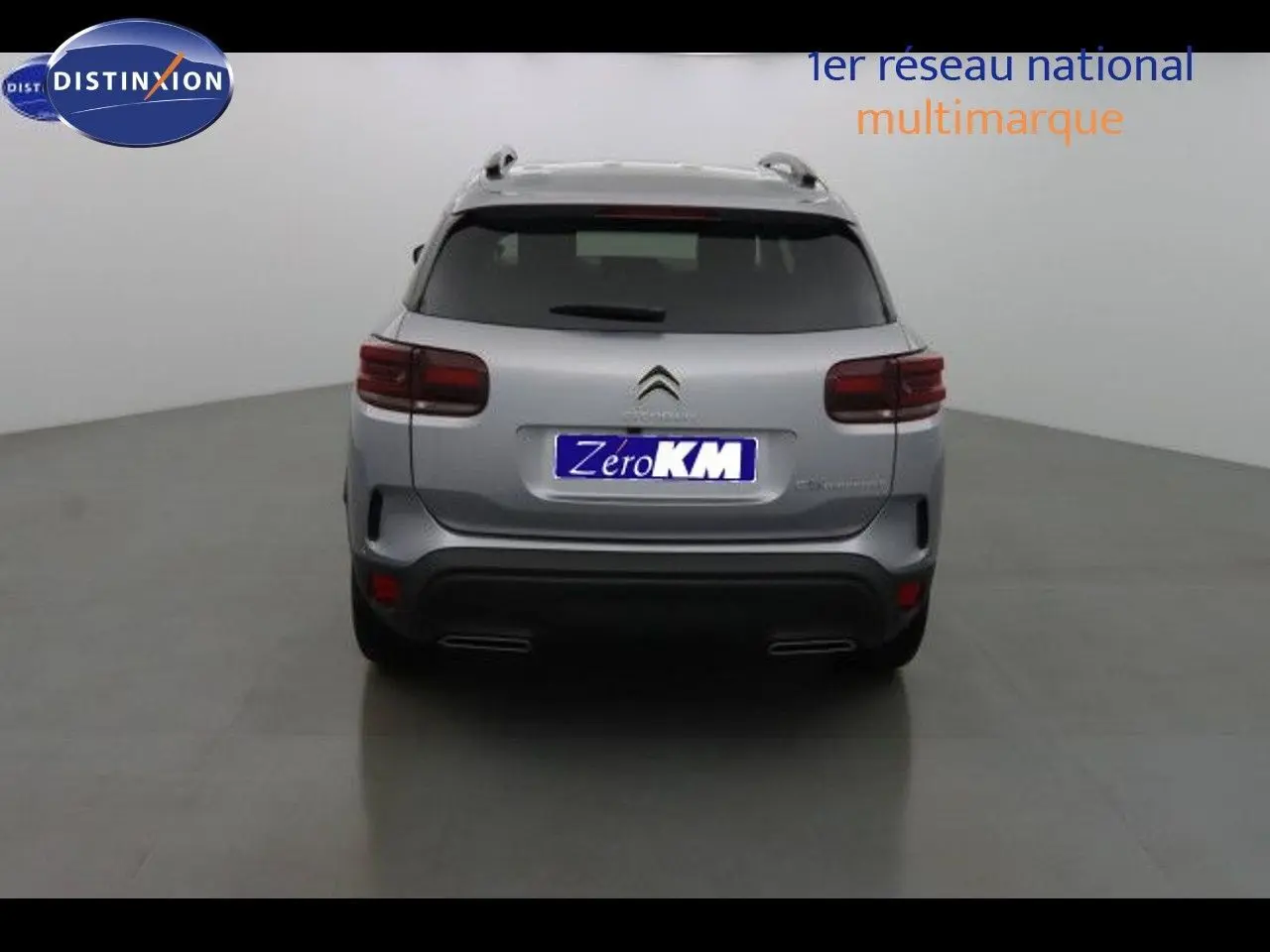 Vue arrière d'un Citroën C5 Aircross 2022 gris Artense métallisé avec feux arrière foncés et double sortie d'échappement intégrée.