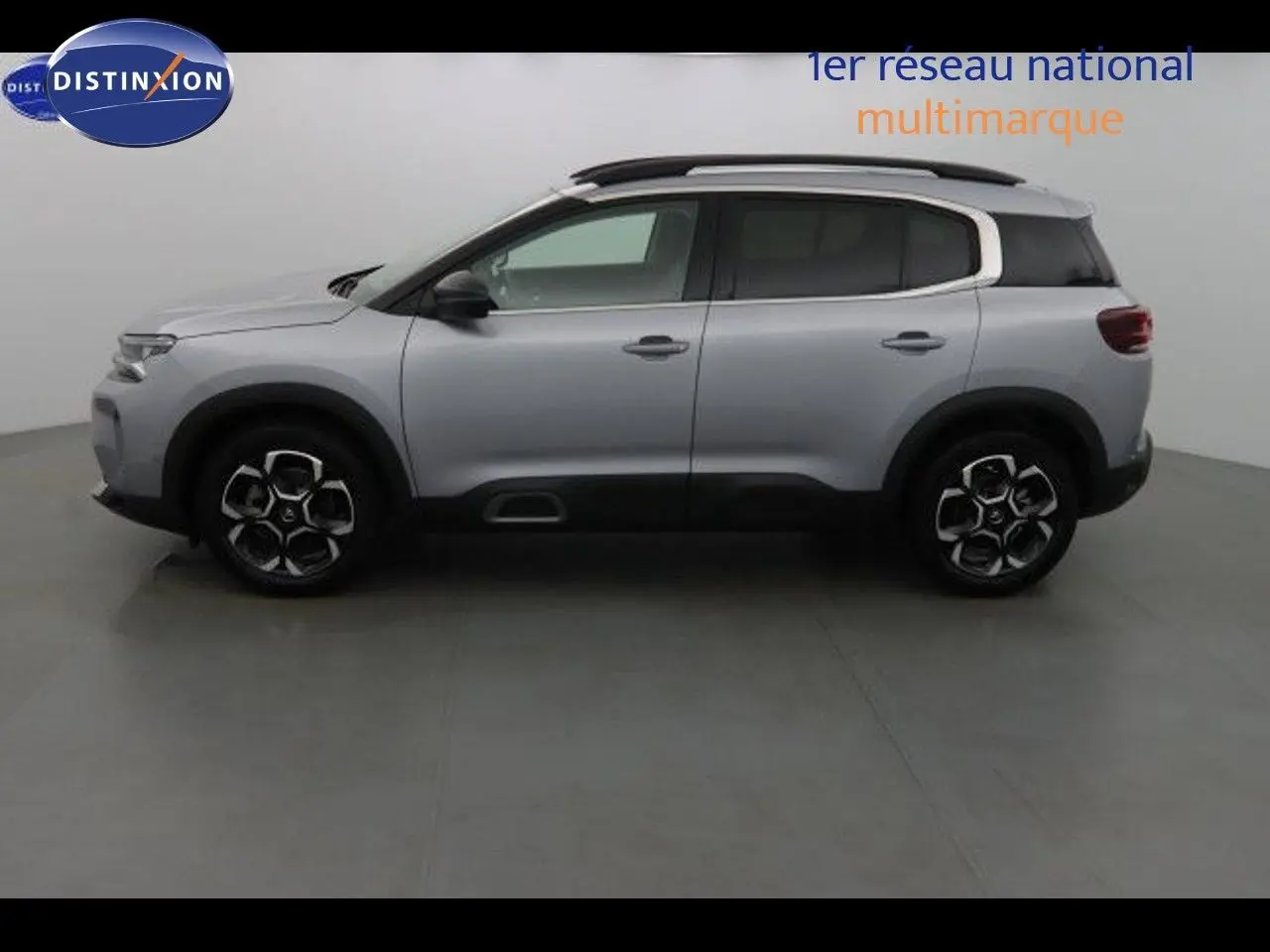 Profil côté gauche du Citroën C5 Aircross gris Artense métal avec jantes bi-ton et barres de toit noires.
