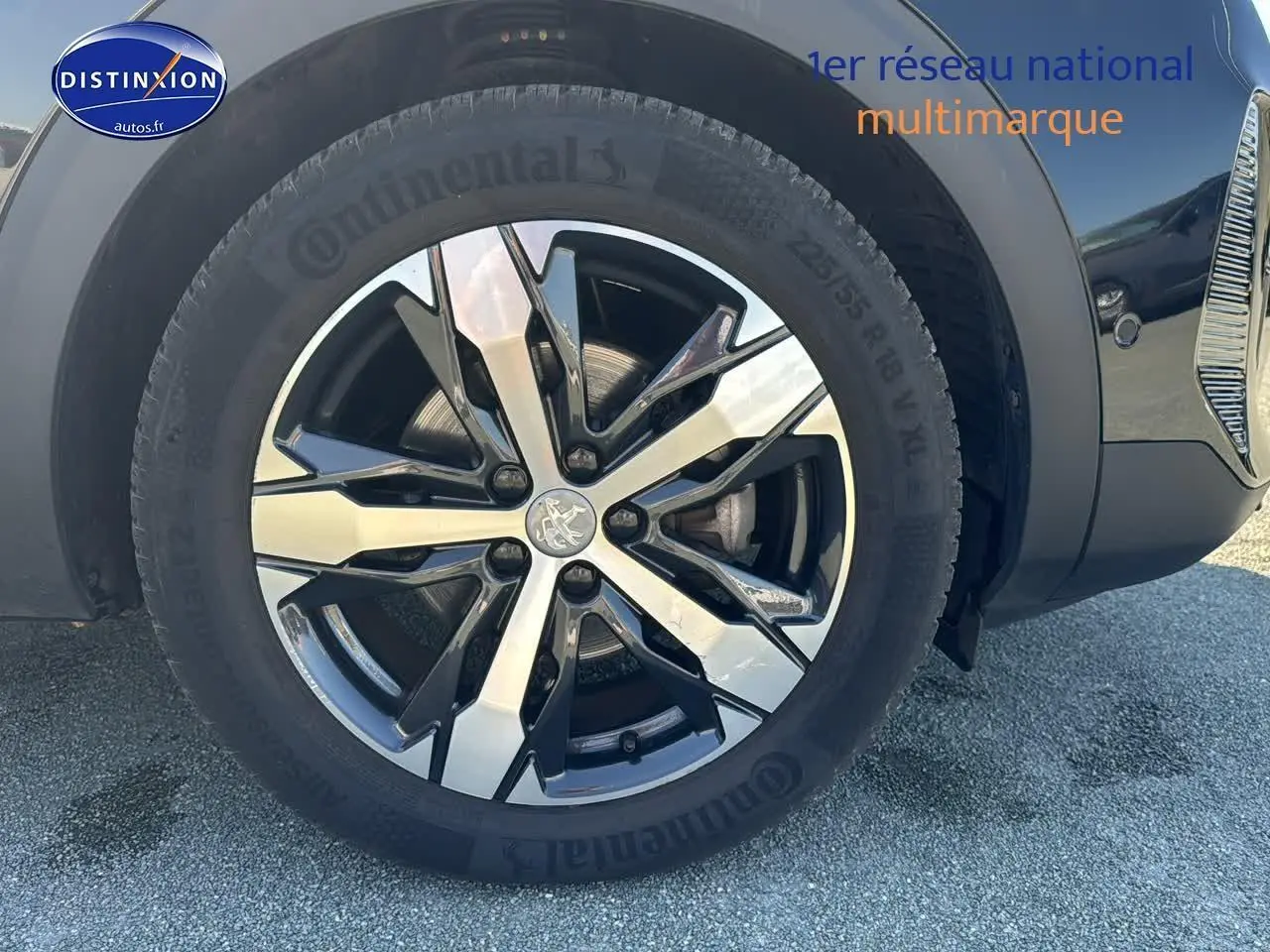 Gros plan sur la jante alu noire et argentée du côté avant droit d'un Peugeot 3008 noir métal 2022.