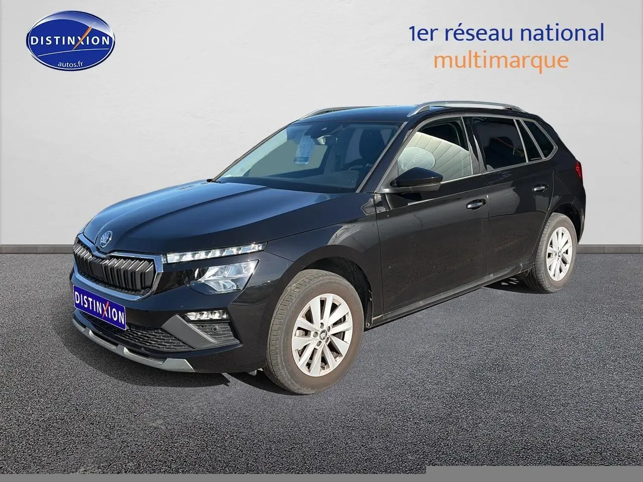 Vue 3/4 avant d'un Skoda Kamiq noir 2025 avec calandre chromée et jantes alu visibles.