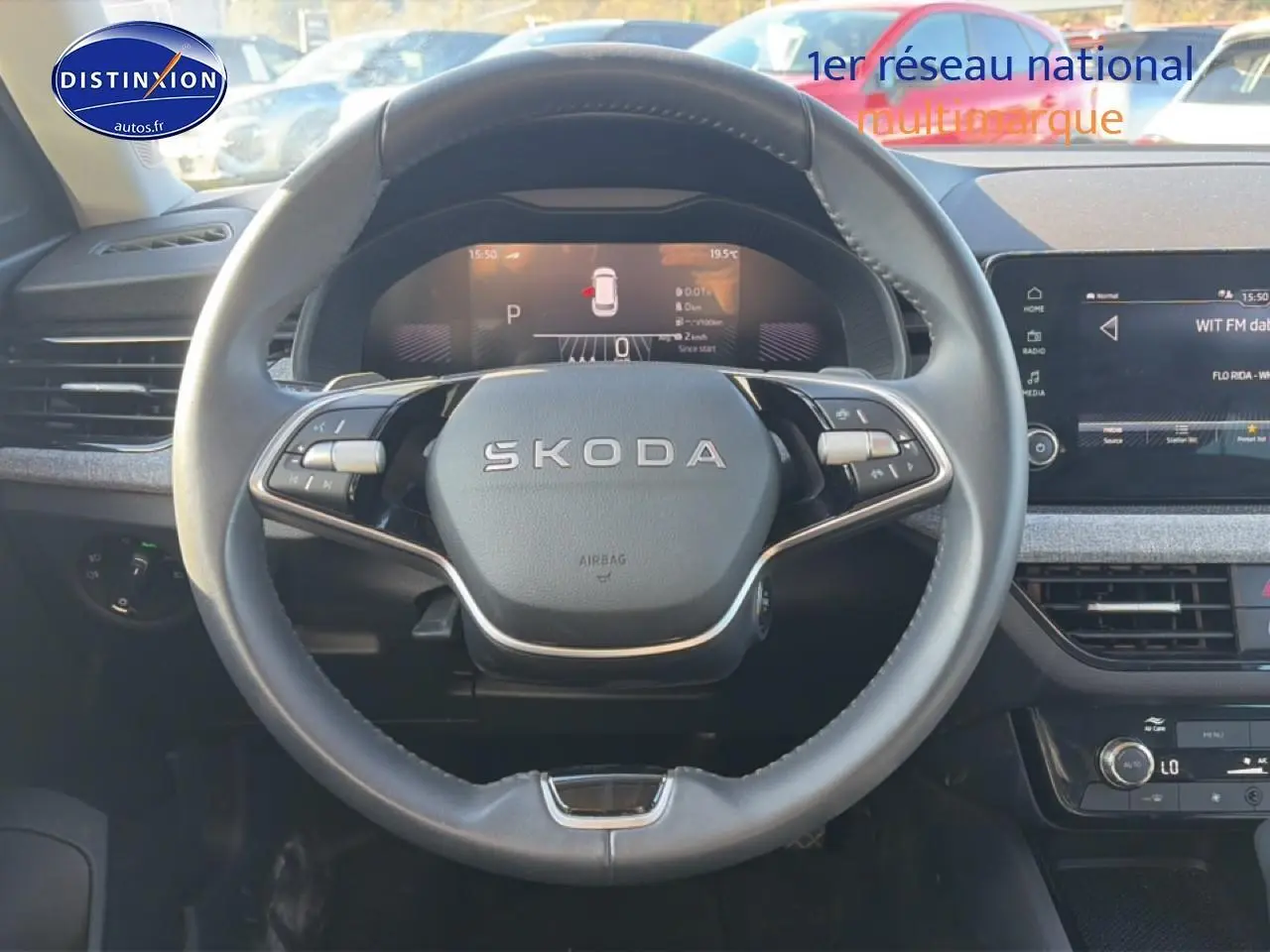 Vue intérieure centrée sur le volant cuir noir SKODA KAMIQ 2025 avec tableau de bord numérique et écran tactile.