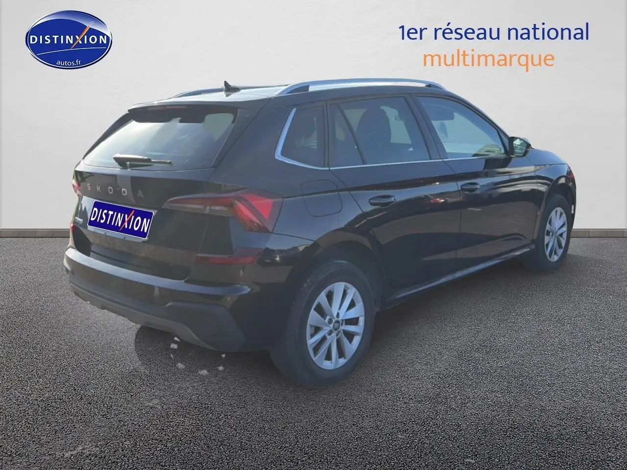 Vue 3/4 arrière droite d'un Skoda Kamiq noir 2025 avec jantes alu et barres de toit visibles.