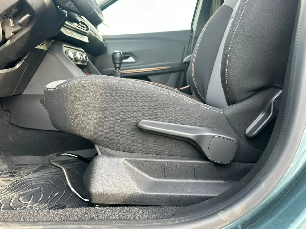 Vue intérieure côté gauche du siège avant tissu noir avec réglage manuel sur Dacia Sandero III Stepway vert cèdre.