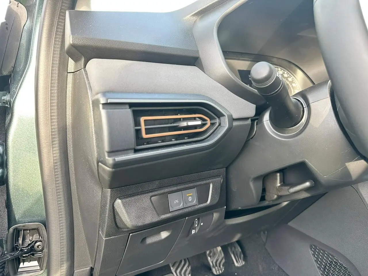 Vue intérieure côté gauche du tableau de bord vert cèdre de la Dacia Sandero III Stepway avec sortie d’air et bouton LPG.