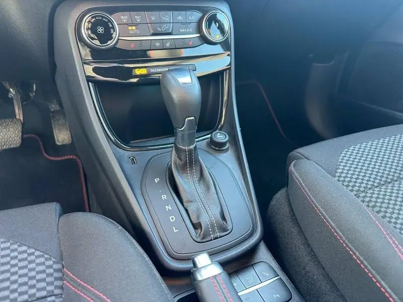 Gros plan sur la console centrale du Ford Puma 2024, montrant le levier de vitesse automatique et les commandes de climatisation.