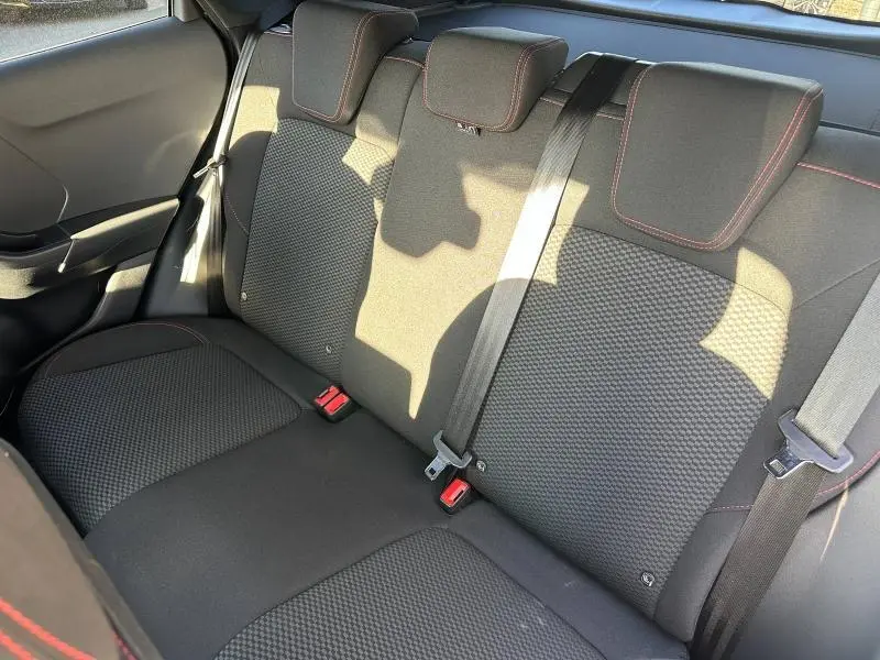 Vue intérieure du siège arrière droit du Ford Puma 2024 gris Solar, avec ceinture de sécurité et surpiqûres rouges visibles.