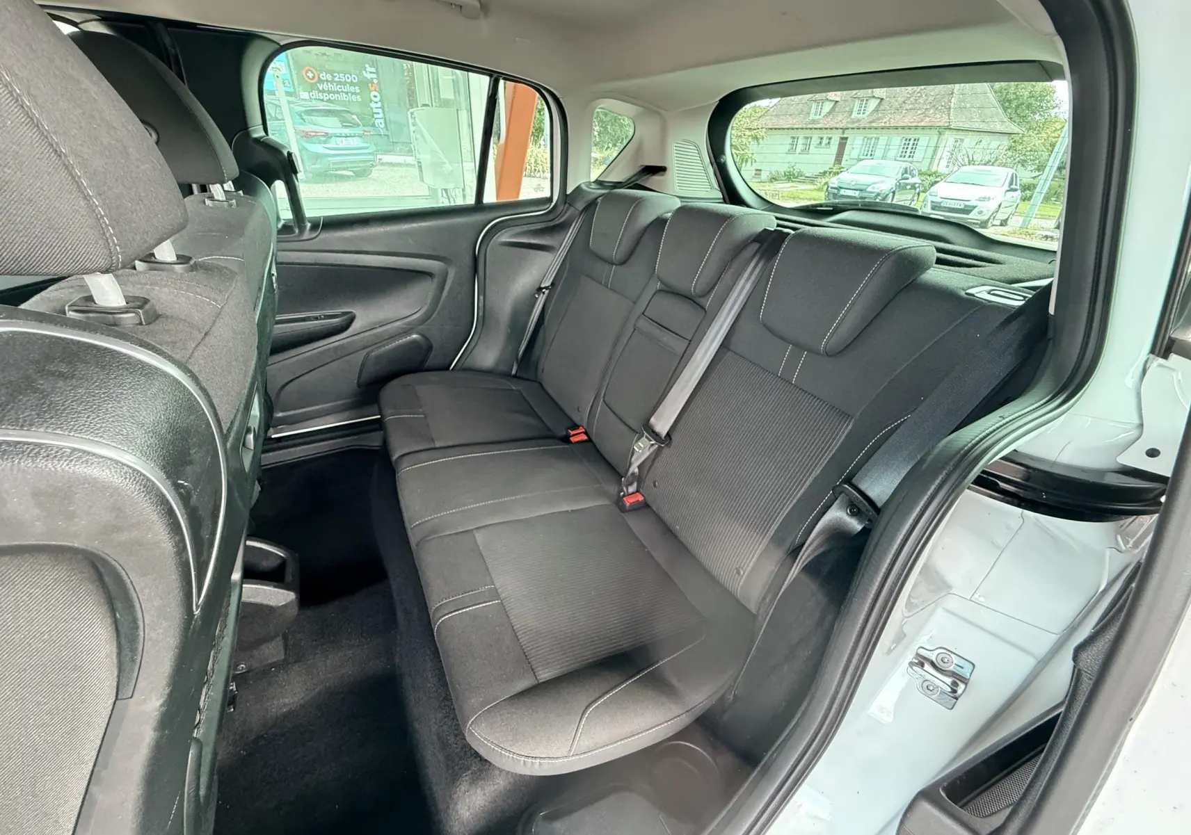 Vue intérieure arrière côté droit du Ford B-MAX blanc 2014 montrant les sièges arrière en tissu gris noir.