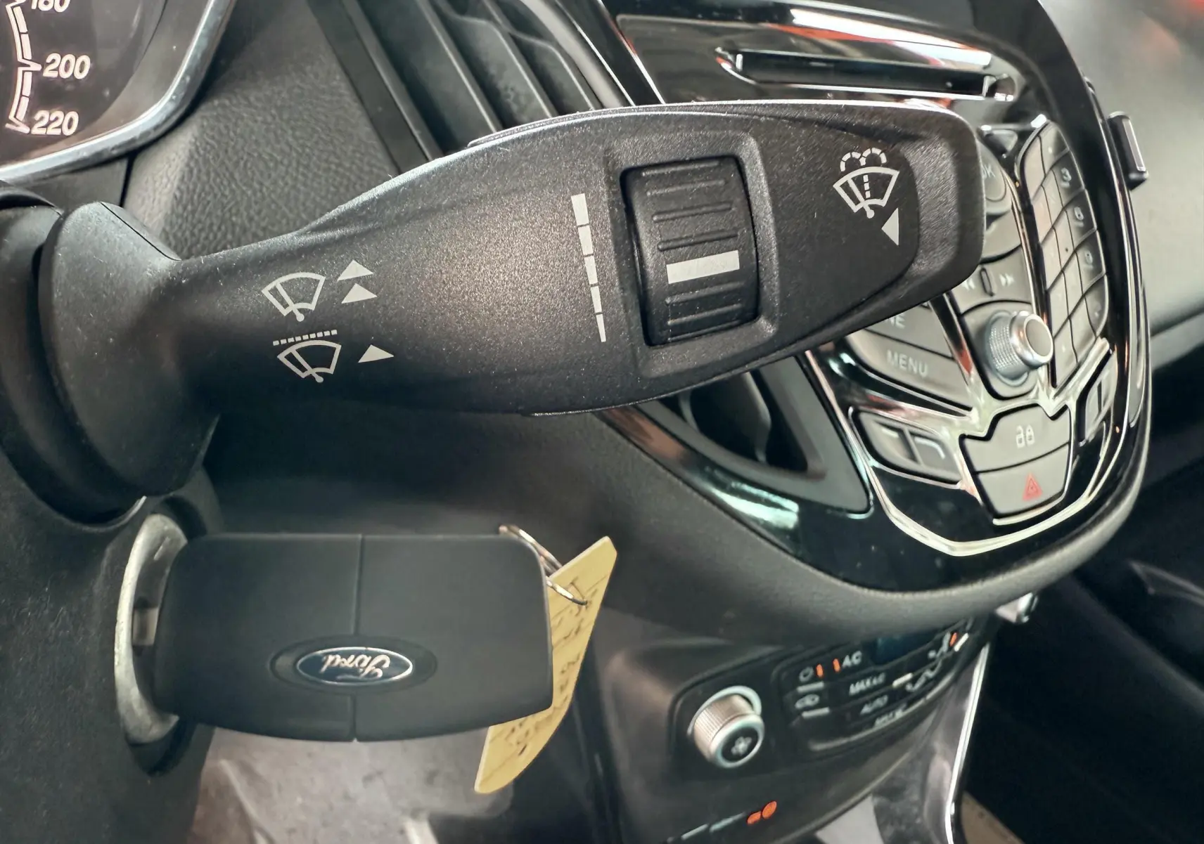 Gros plan sur la commande d’essuie-glace et la clé Ford insérée dans le contact d’un Ford B-MAX blanc, intérieur noir.