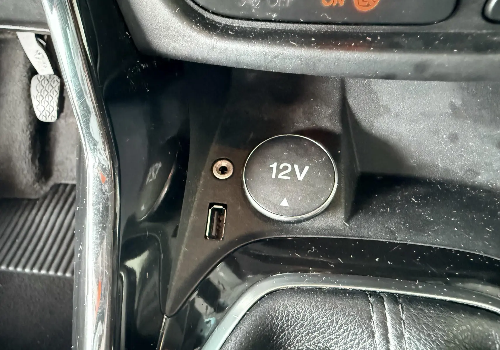 Gros plan sur la console centrale noire du Ford B-MAX, montrant la prise 12V, port USB et prise jack.