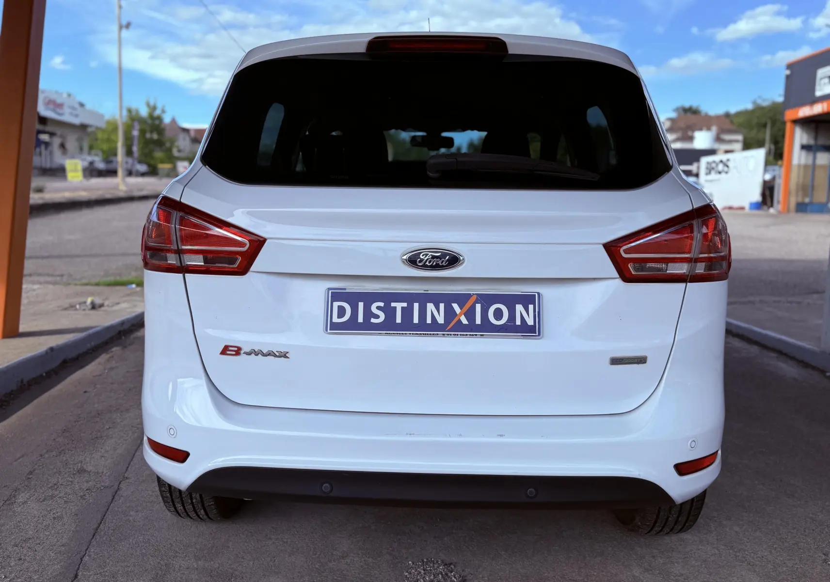Vue arrière d'une Ford B-MAX blanche avec logo et plaque d'immatriculation Distinxion visible.