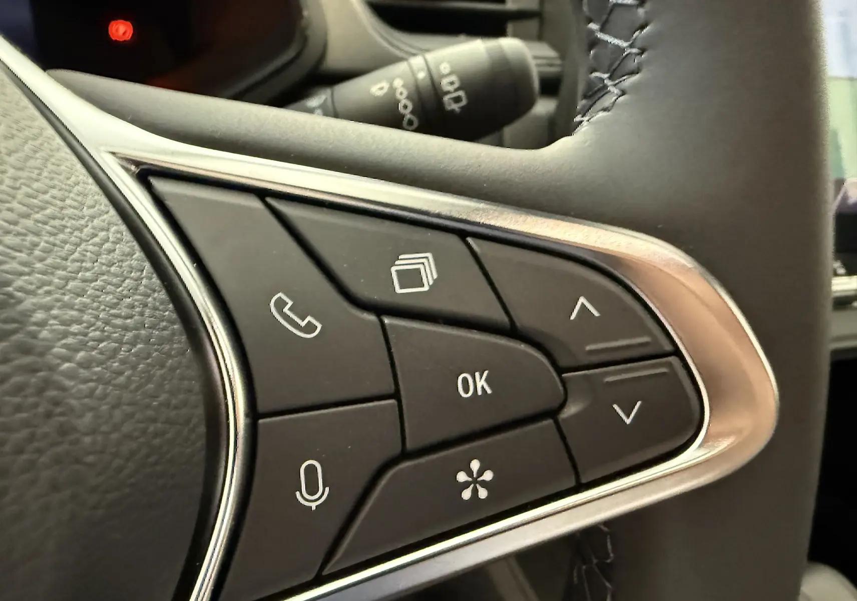 Gros plan sur les commandes au volant du Renault Captur gris cassiopée, avec boutons multifonctions et finition chrome.