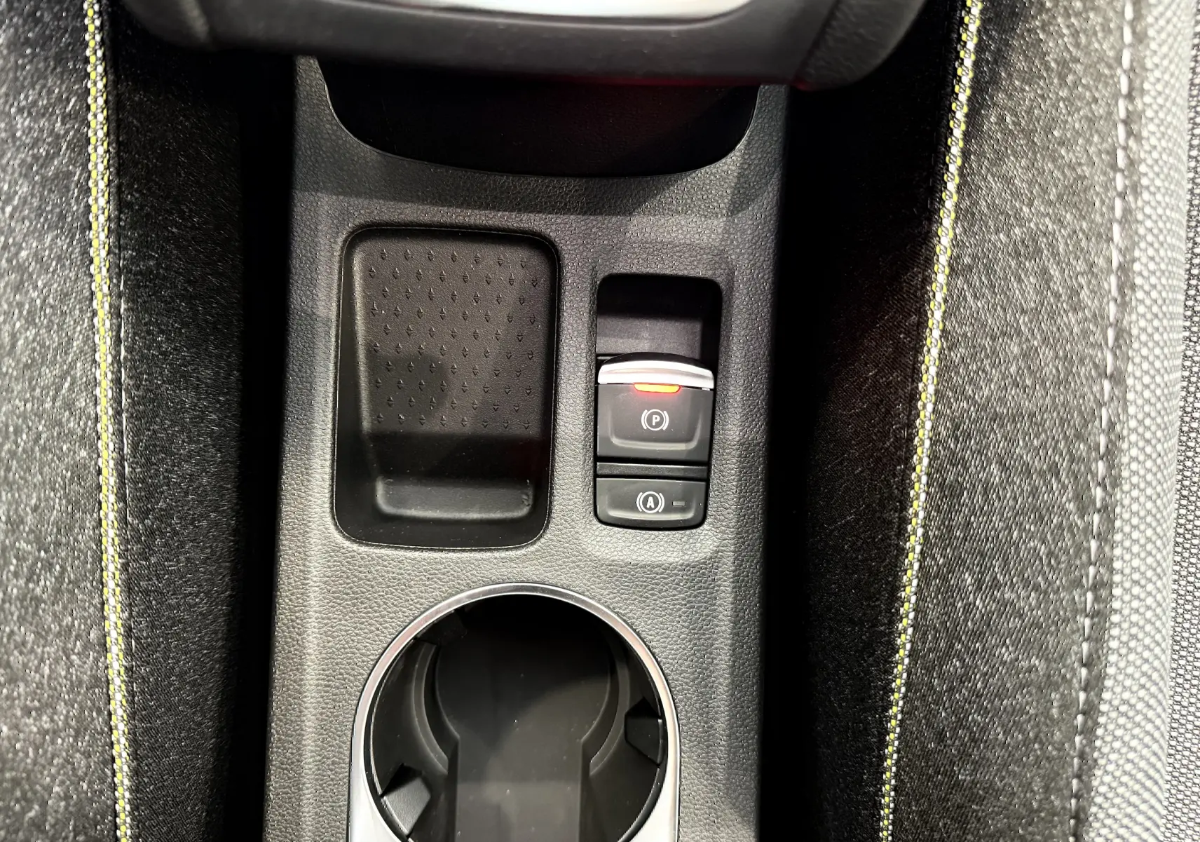 Gros plan sur la console centrale du Renault Captur gris cassiopée, mettant en valeur les commandes de frein à main et démarrage auto.