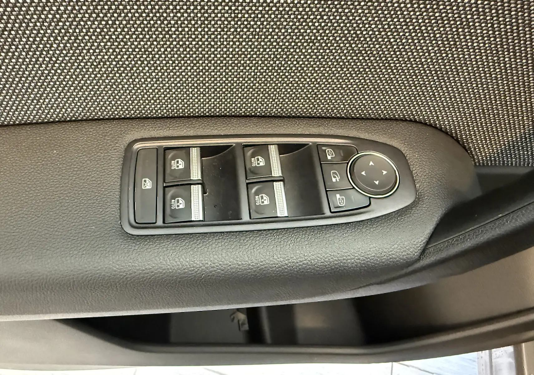 Panneau de commandes des vitres électriques et rétroviseurs sur la porte intérieure côté conducteur d'un Renault Captur gris 2025.