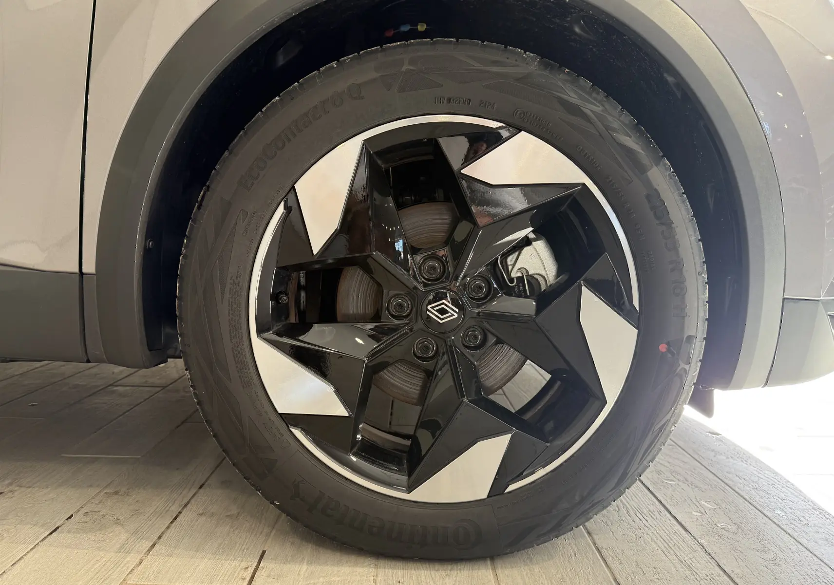 Gros plan sur la roue avant gauche du Renault Captur gris Cassiopée métal avec jante noire et argentée au design géométrique.