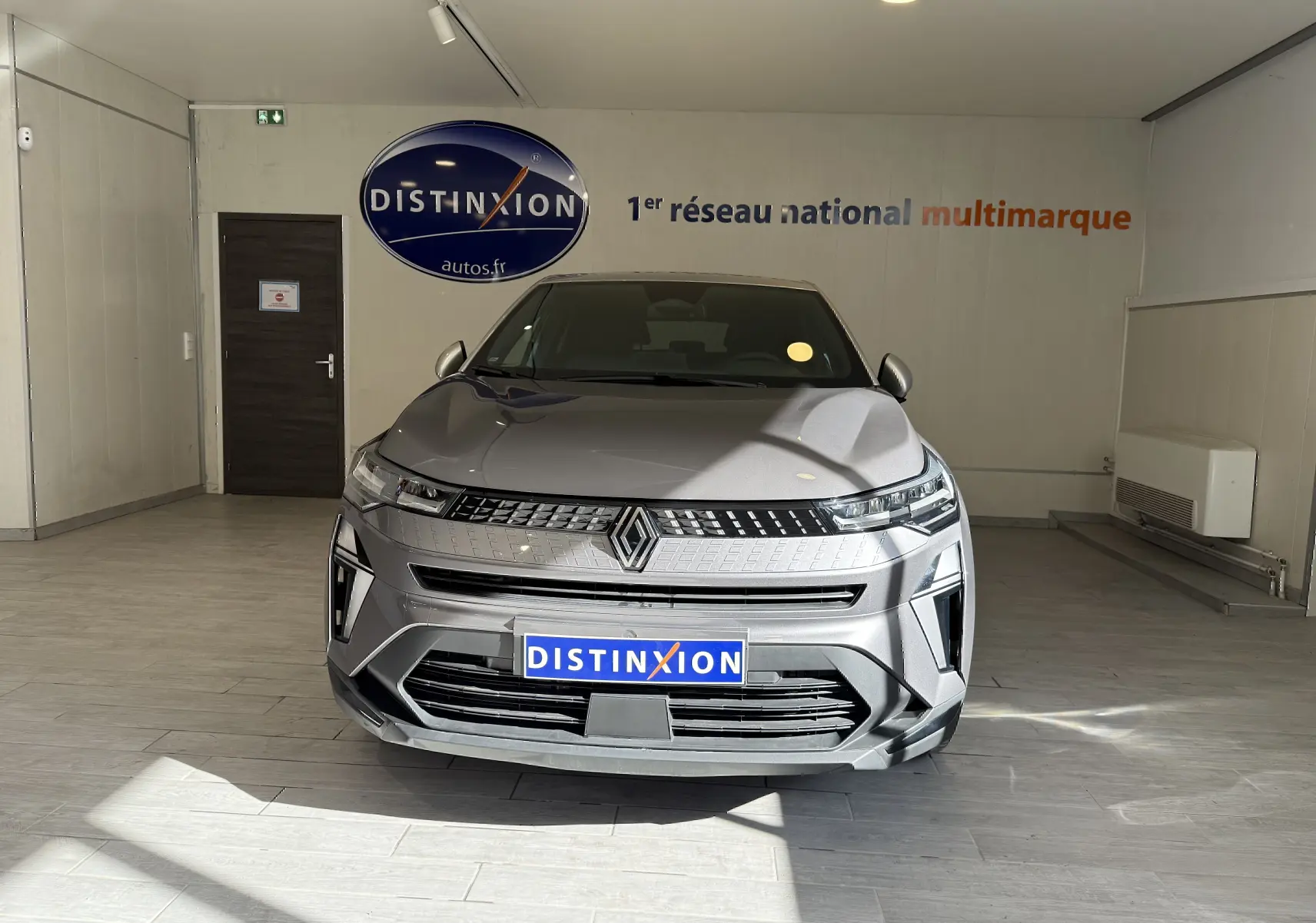 Vue frontale d'un Renault Captur 2025 gris cassiopée métal avec calandre moderne et logo Renault bien visible.