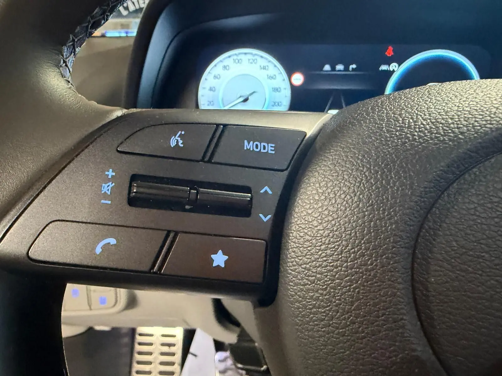 Gros plan sur les commandes du volant noir du Hyundai Bayon 2025, avec compteurs numériques en arrière-plan.