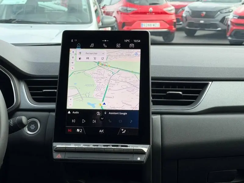Vue intérieure du tableau de bord du Renault Captur 2025 avec écran tactile central affichant la navigation et commandes climatisation.