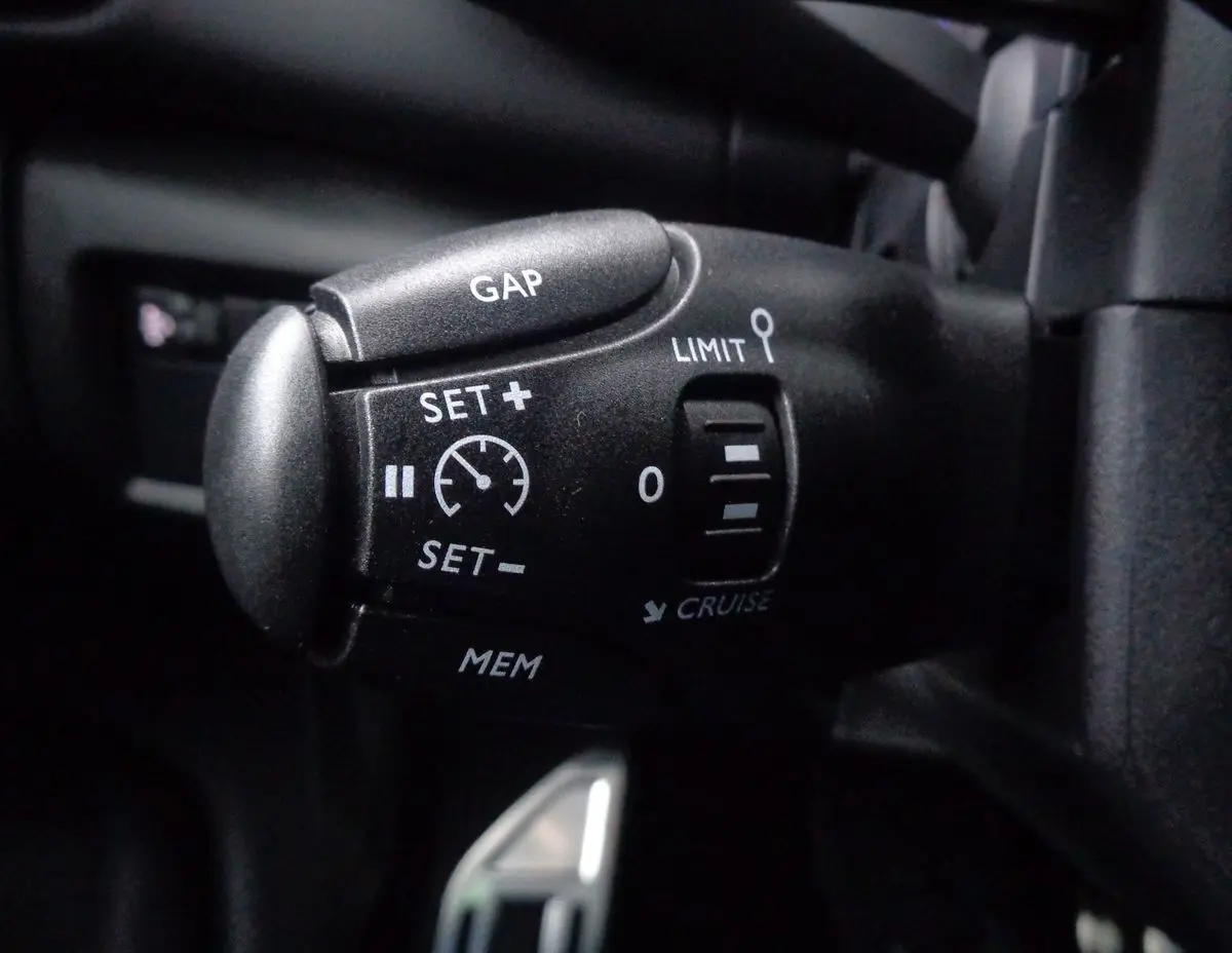 Gros plan sur la commande de régulateur de vitesse du Citroën C5 Aircross noir métal, côté gauche du volant.