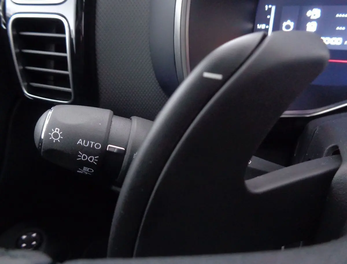 Gros plan sur la commande des phares automatique à gauche du volant du Citroën C5 Aircross noir métal 2022.