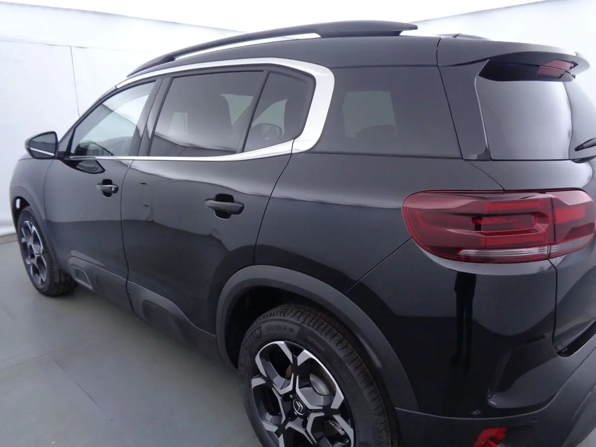 Vue 3/4 arrière gauche du Citroën C5 Aircross noir métal avec jantes biton et vitres teintées.