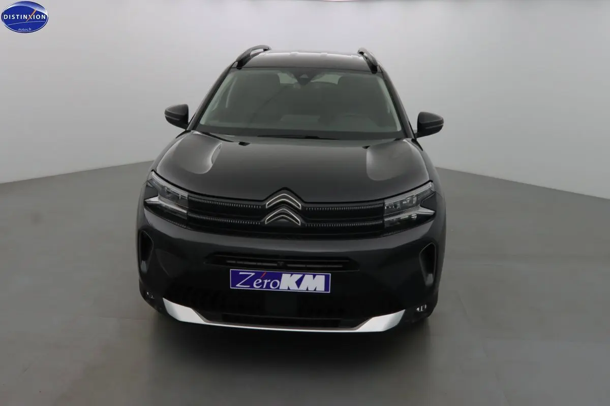 Citroën C5 Aircross noir métal vue de face dans un studio, mettant en valeur la calandre et les phares LED distinctifs.