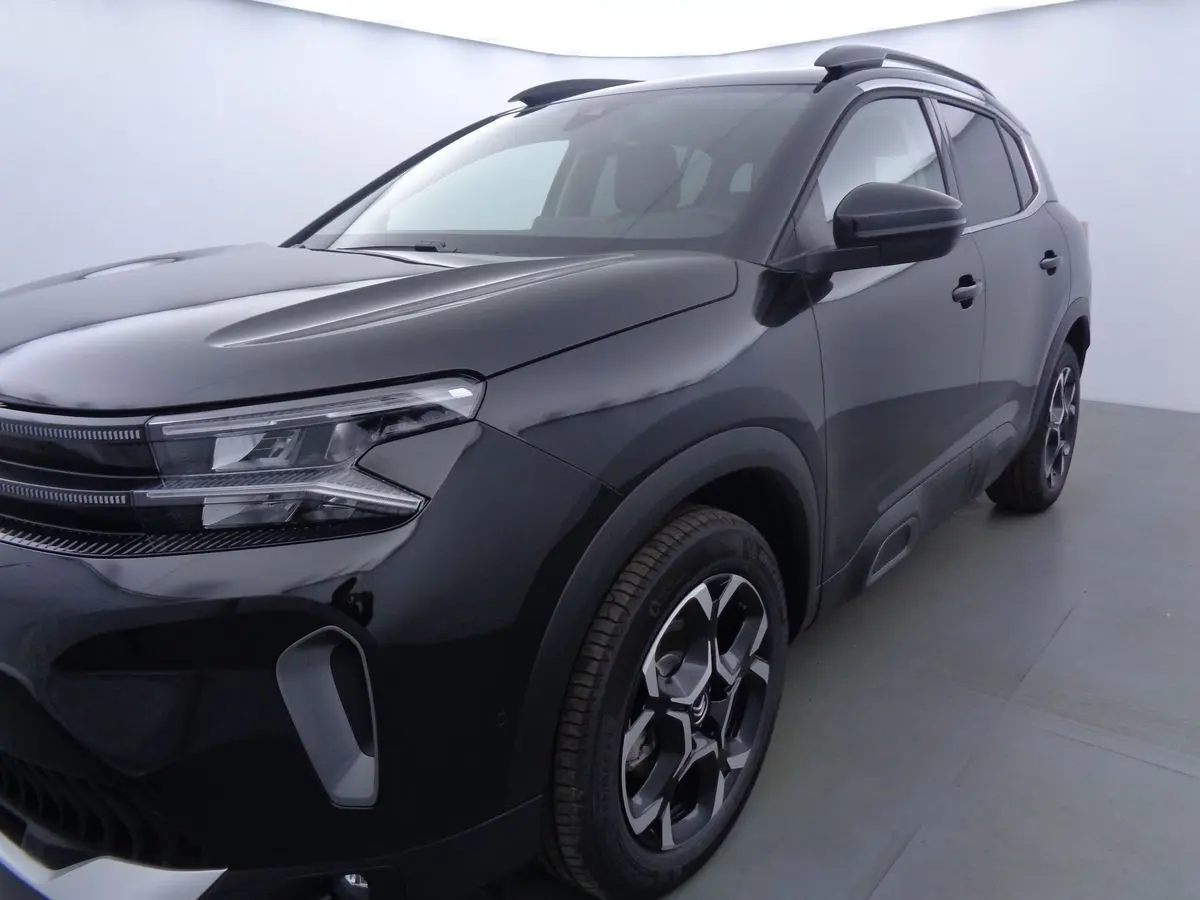 Vue 3/4 avant droite d'un Citroën C5 Aircross noir métal avec jantes bi-ton et phares LED distinctifs.
