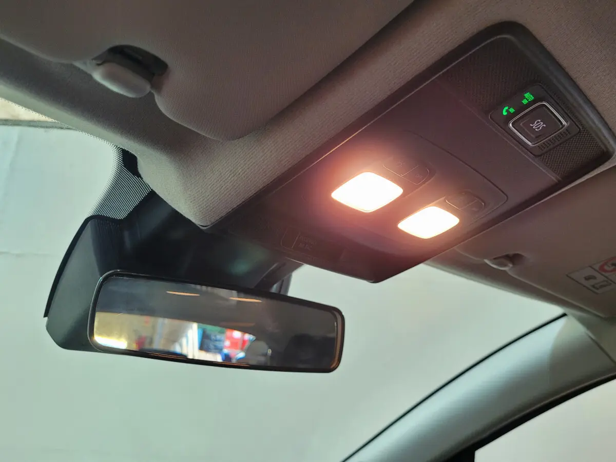 Vue intérieure du plafonnier et du rétroviseur central allumé d’une Renault Clio gris foncé 2025.