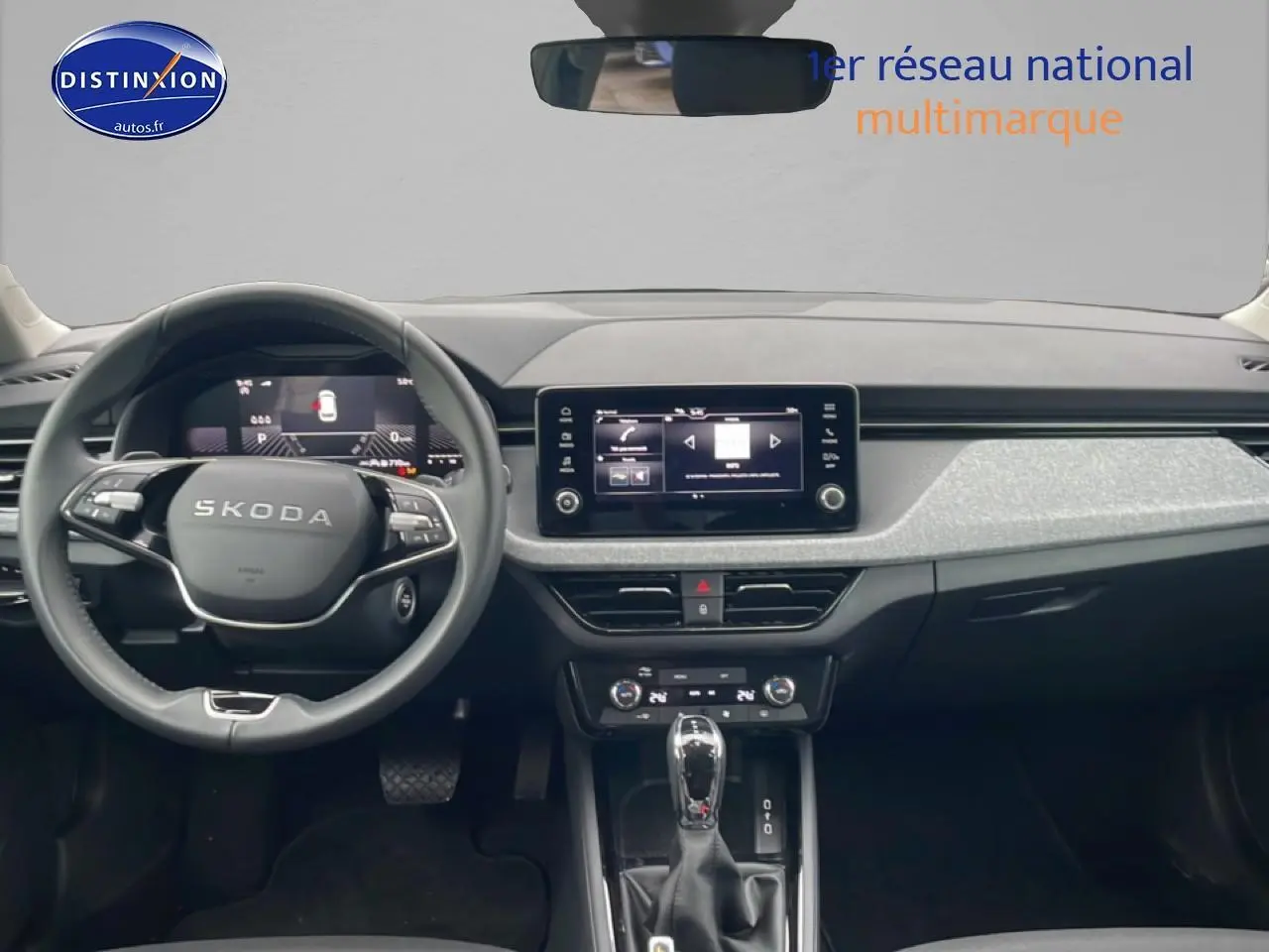 Vue intérieure frontale du tableau de bord noir et gris clair du Skoda Kamiq 2025 avec écran tactile et volant multifonction.