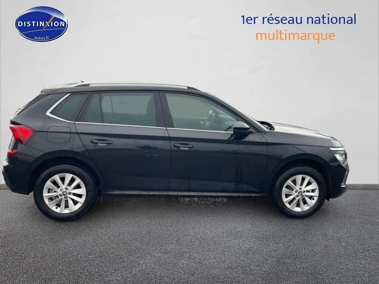 Vue de profil côté gauche d'un Skoda Kamiq noir 2025 avec jantes alu et barres de toit chromées.