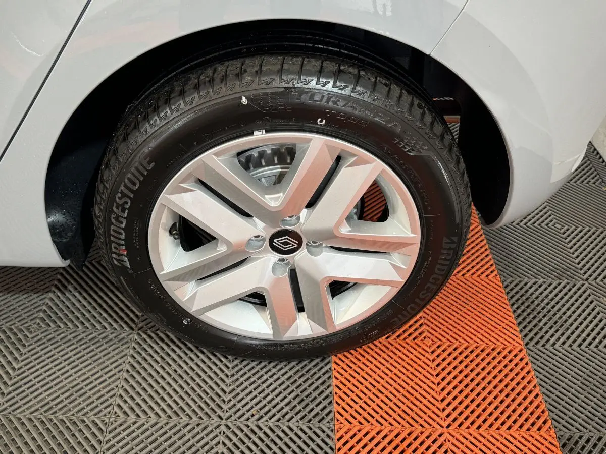 Gros plan sur la roue avant droite d'une Renault Clio gris clair, avec jante alliage et pneu Bridgestone.