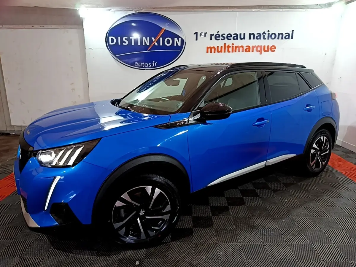 Peugeot 2008 BlueHDi 130 GT bleu en 3/4 avant droit, toit noir et jantes alliage distinctives.