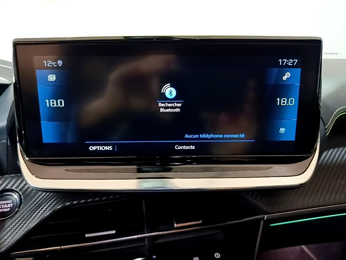 Écran tactile central du tableau de bord du Peugeot 2008 GT bleu, affichant la recherche Bluetooth et la température à 18°C.