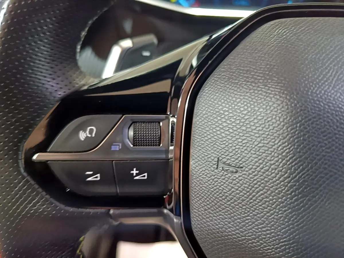 Gros plan sur les commandes gauche du volant cuir noir du Peugeot 2008 BlueHDi 130 GT 2021.