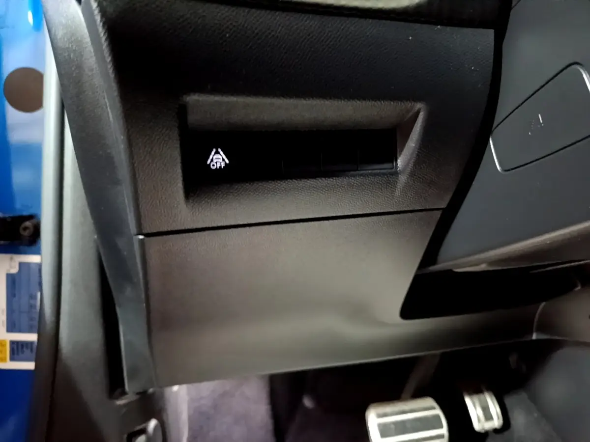 Détail intérieur côté gauche du tableau de bord du Peugeot 2008 Bleu avec bouton d’activation d’aide à la conduite.