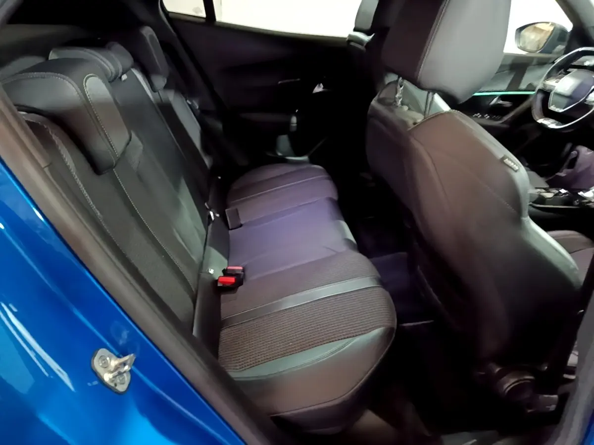 Vue intérieure côté gauche sur la banquette arrière noire et le tableau de bord du Peugeot 2008 bleu 2021.