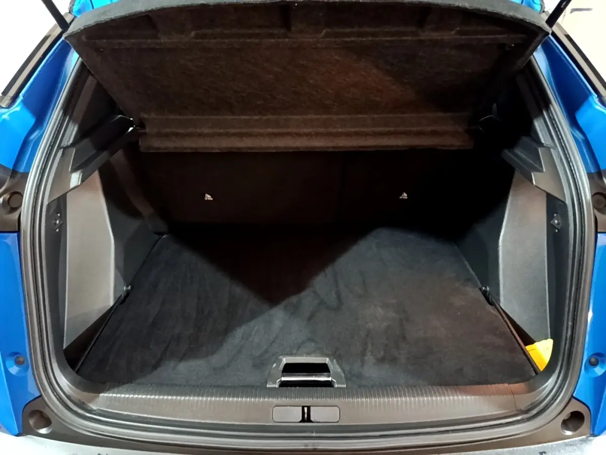 Coffre ouvert vu de l'arrière d'un Peugeot 2008 Bleu, montrant l'espace de chargement et la tablette cache-bagages.