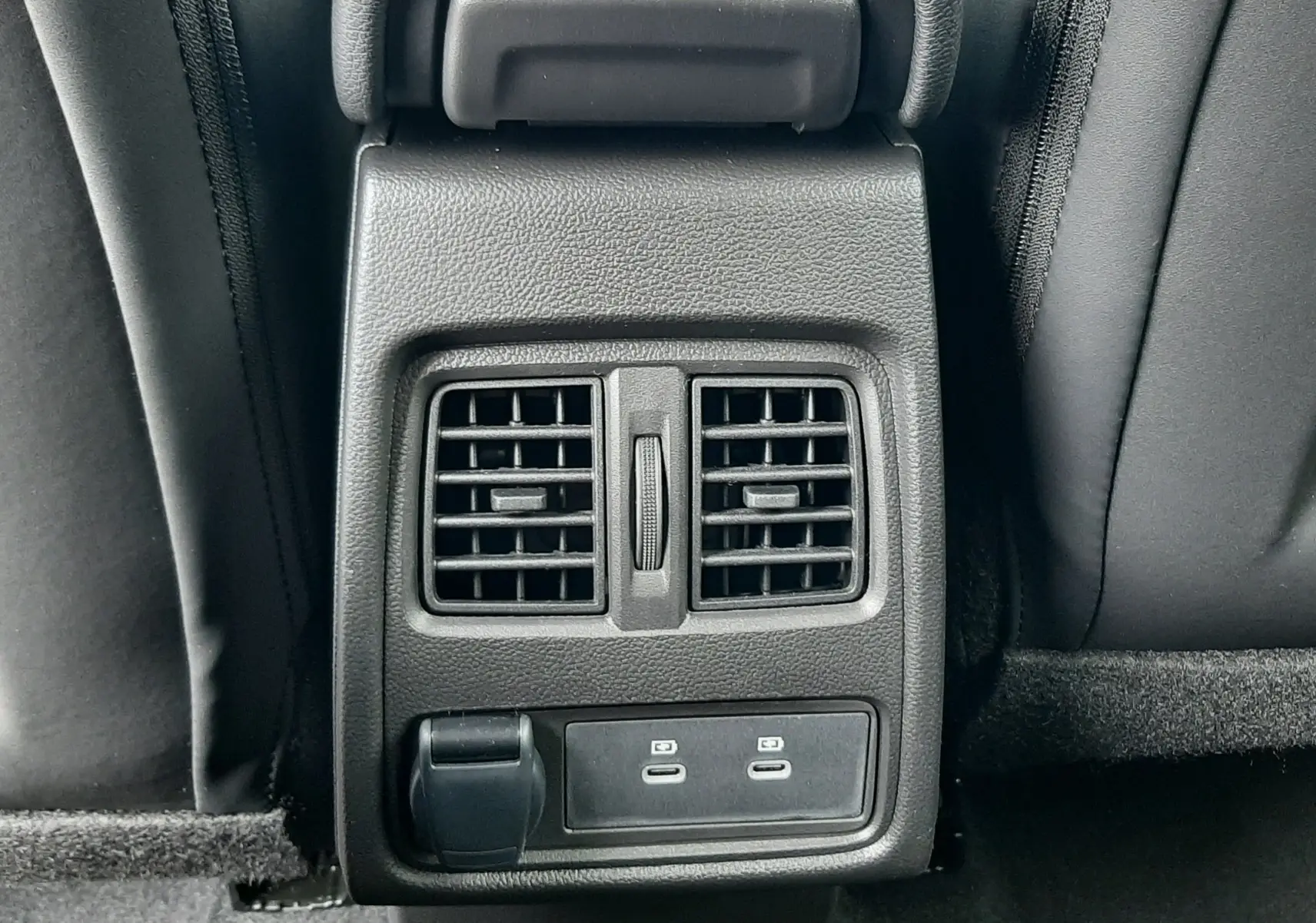 Vue rapprochée de la console arrière noire du Renault Captur 2026 avec bouches d’aération et ports USB.