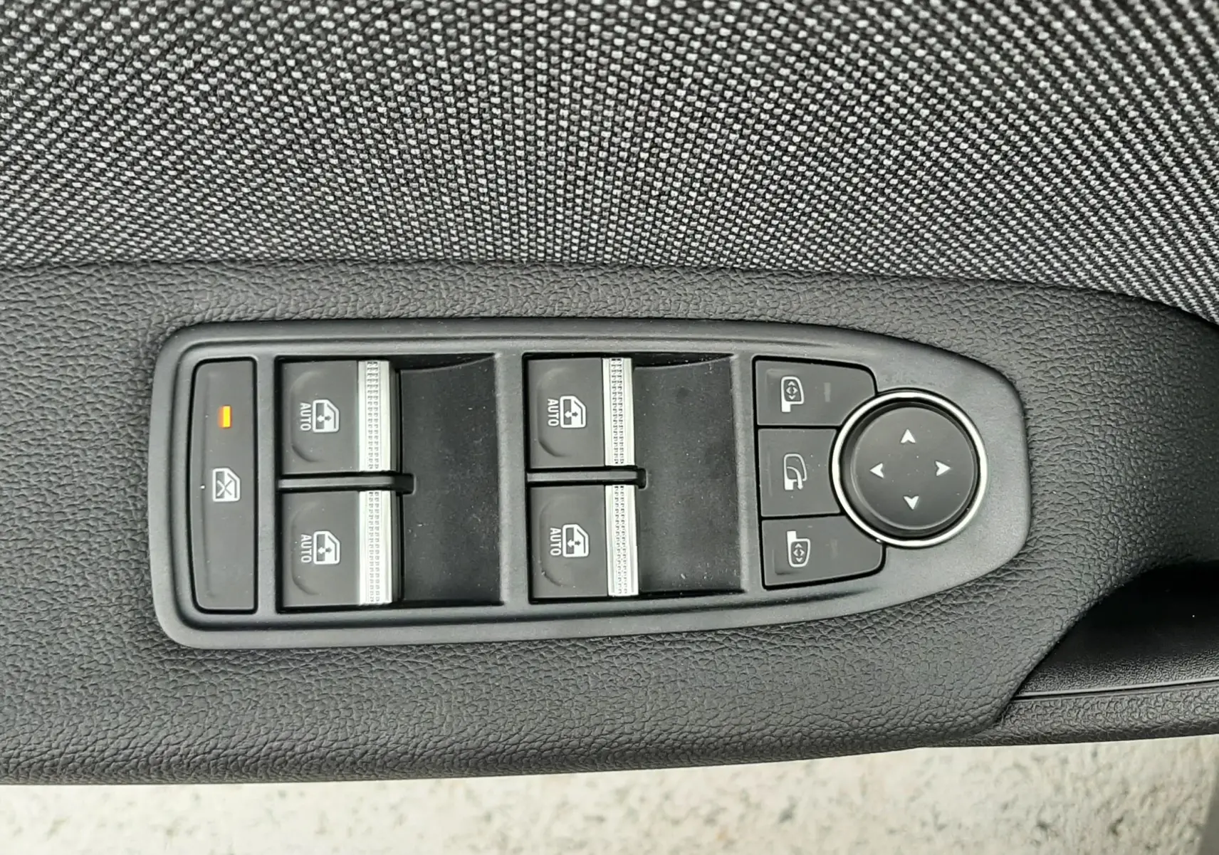 Panneau de commandes des vitres électriques et rétroviseurs sur la porte côté gauche d’un Renault Captur gris Cassiopée toit noir.