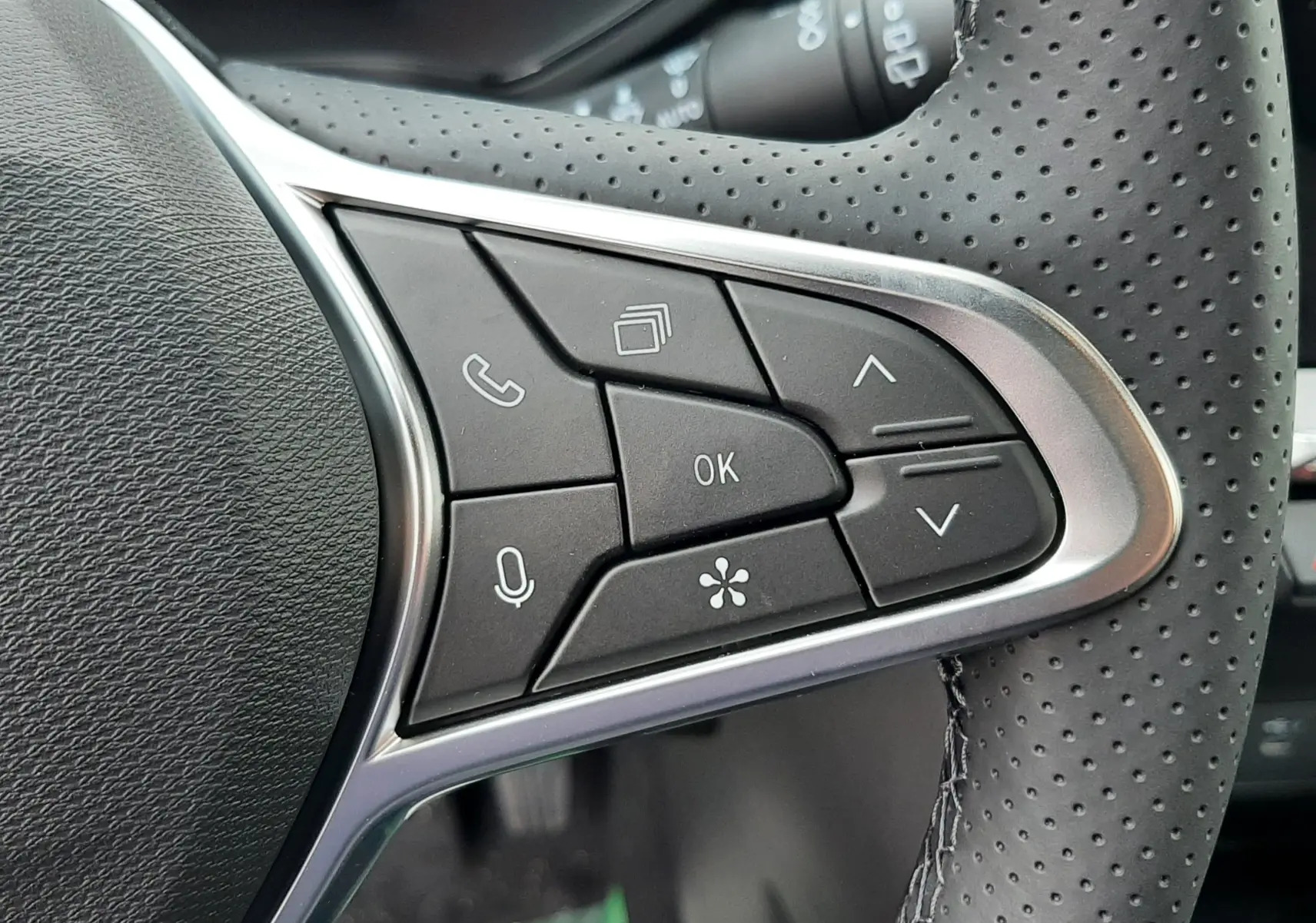 Gros plan sur les commandes multifonctions à droite du volant perforé du Renault Captur E-Tech hybride 2026.