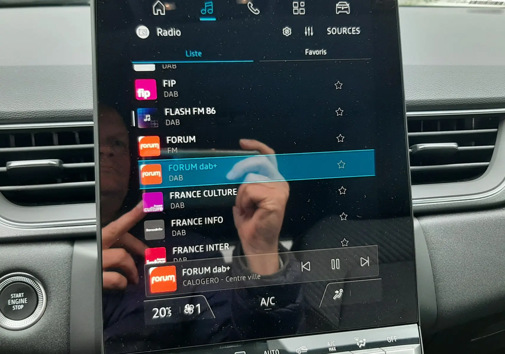 Écran tactile central du tableau de bord du Renault Captur E-Tech gris cassiopée, affichant la liste des radios DAB.