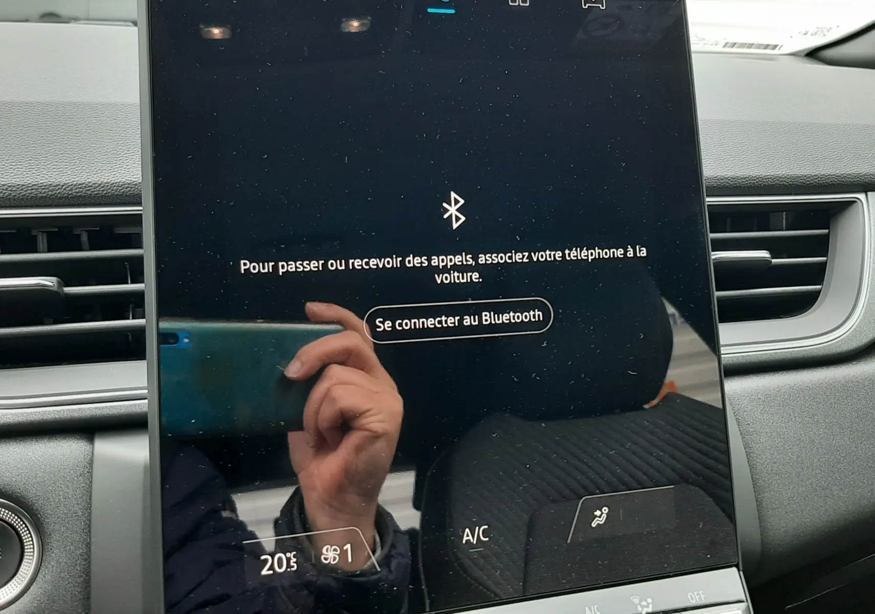 Écran tactile central du Renault Captur E-Tech gris cassiopée, affichant la connexion Bluetooth, intérieur en tissu gris.