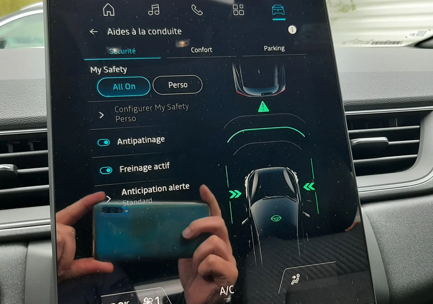 Écran tactile central du Renault Captur E-Tech gris cassiopée, affichant les aides à la conduite en mode sécurité.